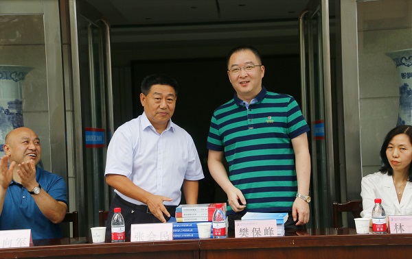 新乡市牧野区税务局党委书记、局长樊保峰向博鱼网页版_博鱼（中国）党委书记张会民赠送税法知识书籍.jpg